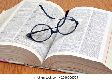Vannes, France, December 2, 2021: Open french dictionary lying on a table with glasses