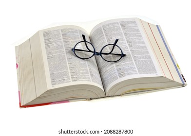 Vannes, France, December 2, 2021:
Open french dictionary on white background with glasses on it