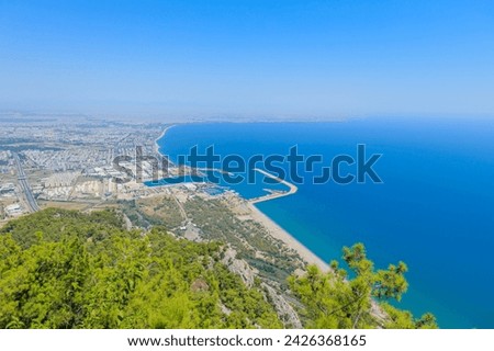 From the vantage point of the Tunektepe Cable Car, a panoramic view of Antalya unfolds. The city's dense architecture sprawls to the left, while the deep blue coastline stretches to the right. Stock photo © 