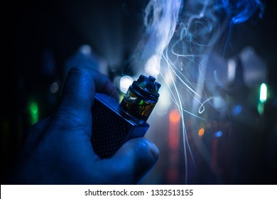 Vape concept. Electronic Cigarette vape explosion. Smoke clouds and vape liquid bottles on dark background. Light effects. Useful as vape advertisement. Selective focus - Powered by Shutterstock