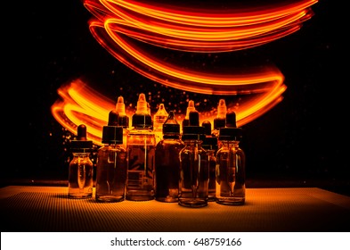 Vape concept. Smoke clouds and vape liquid bottles on dark background. Light effects. Useful as background or vape advertisement or vape background.