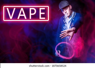 Vape logo next to man. Smoke cloud in form of a ring. Guy makes a round vape cloud of smoke. Vape neon sign. Steam e-cigarette. Young vaper is in smoke from vaping. Concept - vaping device tricks - Powered by Shutterstock