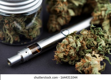 Vape Pen. Cannabis Marijuana Vaporizer. Cannabis Marijuana Buds and pen vaporizer close up image. CBD and THC vaping products. Vape CBD or THC Oil. Vaping Marijuana and Cannabis. Vaporizer Marijuana 