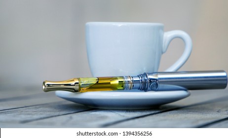 Vape Pen and Coffee Cup, Vaping THC and CBD, Cannabis and Marijuana Oil 