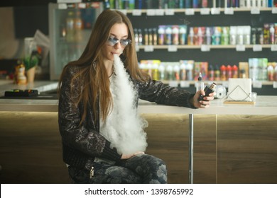 Vape Teenager. Portrait Of Young Cute Girl In Sunglasses Smoking An Electronic Cigarette In Vape Bar. Bad Habit That Is Harmful To Health. Vaping Activity.