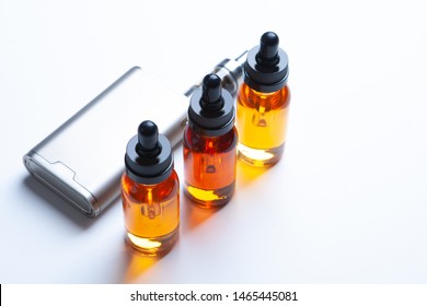 Vaping device, electronic cigarette, vape  on the white background. e- liquid, e-juice in the bottles and e-cigarette (vape) isolated on the white background with copyspace