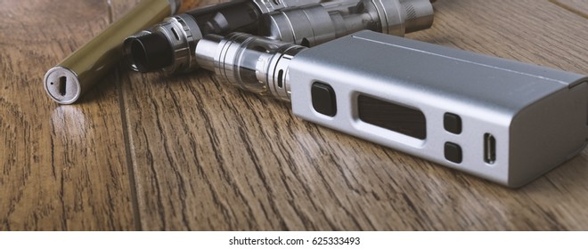 Vaping Pen, Vape Devices, Mods For Electronic Cigarette Or E Cigarette, E Cig, On A Wooden Background.