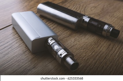 Vaping pen, vape devices, mods for electronic cigarette or e cigarette, e cig, on a wooden background.