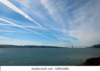 Vapour trails on blue sky. Golden Gate Bridge in the background