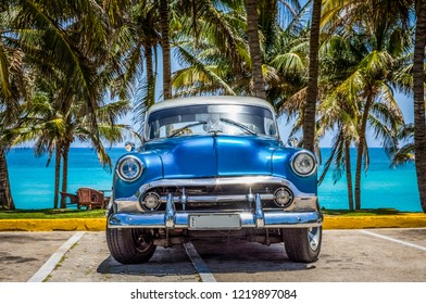 Varadero, Cuba - June 21, 2017: HDR - American blue Buick classic car with white roof parked under palms in Varadero Cuba - Serie Cuba Reportage - Powered by Shutterstock