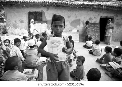 Varanasi / India 20 November 2011,  Rural Indian Village School Children In An Outside Class With Indian National Anthem Book  North India Uttar Pradesh India 