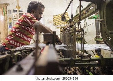 VARANASI, INDIA - 21 FEBRUARY 2015: Worker Repairs Textile Machine In Small Factory.