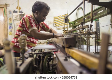 VARANASI, INDIA - 21 FEBRUARY 2015: Worker Repairs Textile Machine In Small Factory.