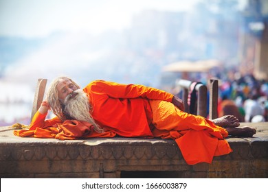 VARANASI, INDIA - JAN 31: Indian Sadhu baba lay down by the bank of sacred river Ganges in Varanasi, Uttar Pradesh India on January 31, 2019.