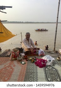 Varanasi / India - July 17 2019: A Guru Sitting By The River Ganges In The Morning Offering Spiritual Advice.