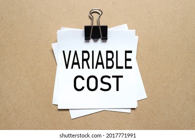 Variable Cost. The Paper Is Clamped With A Clerical Clip. Paper On Wood Background.