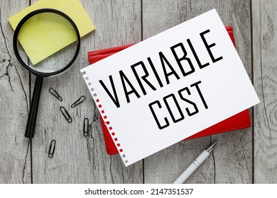 Variable Cost. sheet of paper with text on a red notepad