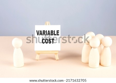 VARIABLE COST text on a easel with wooden figure, meeting concept