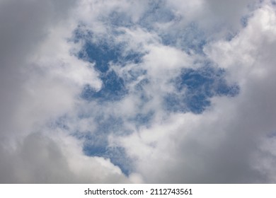 Variable Weather Concept, Close Up View Of White And Grey Cumulus Clouds Forming Around The Blue Sky