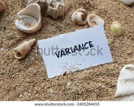 Variance writing on beach sand background.