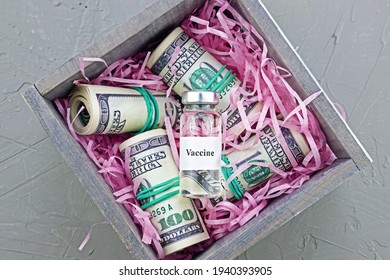 variant of omicron, ampoule of the vaccine lies with rolled-up hundred-dollar bills on paper backing in small wooden box,coronavirus, covid-19, SARS-CoV-2, close-up, top view
