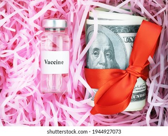 variant of omicron,ampoule with vaccine against the virus with hundred-dollar bills tied in red bow in the form of gift on paper lining for boxes, coronavirus, covid-19, SARS-CoV-2, close-up, top view