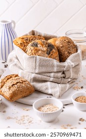 Variation of bread rolls or buns in breadbag  with butter and assorted seeds