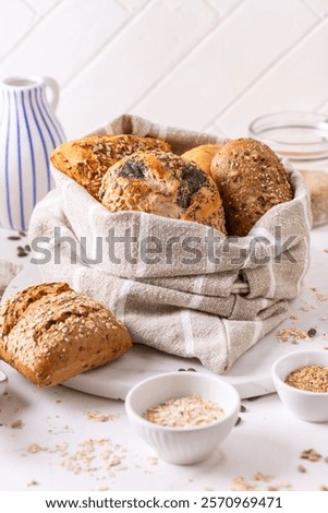 Variation of bread rolls or buns in breadbag  with butter and assorted seeds