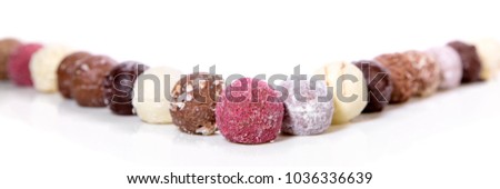 Variation of gourmet chocolate truffles or pralines in a line, white background, header