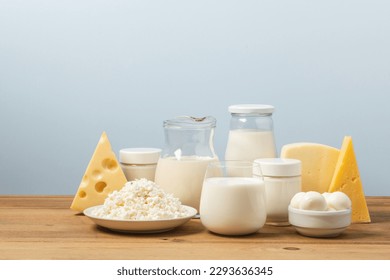 Variation of organic dairy products on wooden table. Farm cheeses, milk, cottage cheese, yogurts on blue background with copy space - Powered by Shutterstock