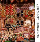 Varied display of traditional richly patterned carpets, rugs, cushion-covers, other textile souvenirs on sale in Khan al-Khalili bazaar, Cairo, Egypt