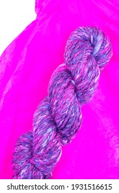 Variegated, Textured, Hand Spun Yarn On Pink Tissue Paper Against A White Background - Seen From Above