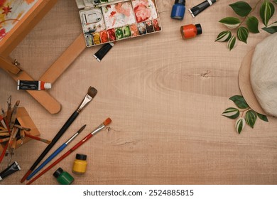 Variety of art supplies with paintbrushes, palette and watercolor on wooden background for a painting session - Powered by Shutterstock