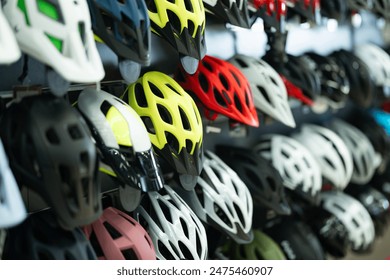 Variety of bicycle helmets in different colors and designs neatly displayed on shelves in specialized bike shop