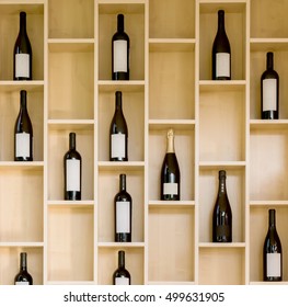 A Variety Of Bottles Of Wine And Champagne In A Wooden Display Case In The Store