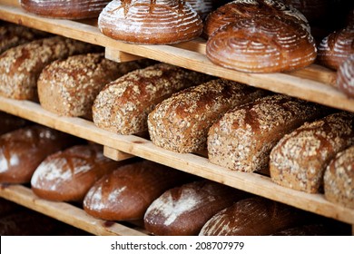 Variety of breads displayed on shelves in bakery - Powered by Shutterstock