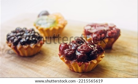 A variety of cake baskets with berries. The cakes are beautifully decorated on a retro-style cooking tray