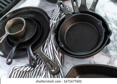 Variety of cast iron frying pans on a marble background.