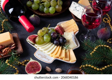 Variety Of Cheese And Fruits Served In Plate As Christmas Tree, On Dark Gray Background With Two Glasses Of Wine. New Year's Eve Party Snack