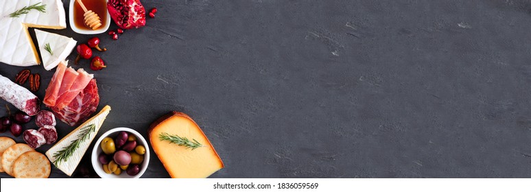 Variety Of Cheese And Meat Appetizers. Top View Corner Border On A Dark Slate Banner Background With Copy Space.