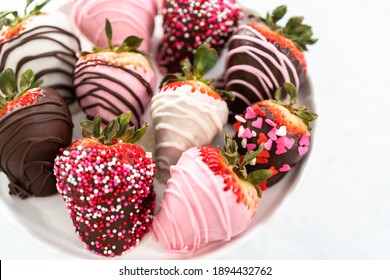 Variety of chocolate dipped strawberries on a cake stand.