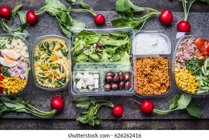  Variety of clean dieting salads in  plastic package and green measuring tape on rustic background, top view. Healthy clean food concept.