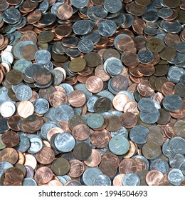 A Variety Of Coins Spread Out Across A Table Top.