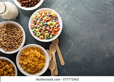Variety of cold cereals in white bowls, quick breakfast for kids overhead shot with copyspace