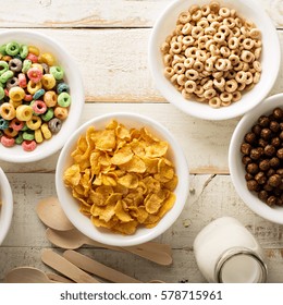 Variety Of Cold Cereals In White Bowls On White Wooden Table, Quick Breakfast For Kids Overhead Shot