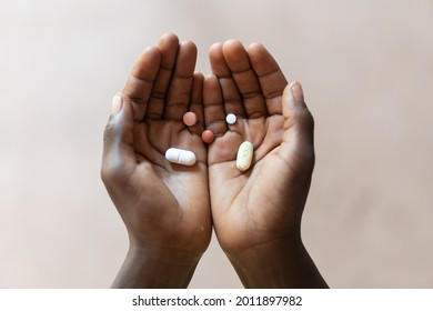 Variety Of Colored Pills Displayed In The Palms Of A Black Child Suggesting Treatment Options