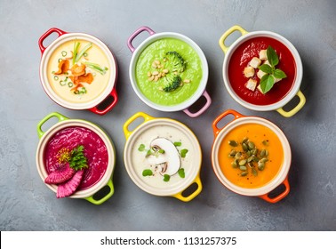 Variety of colorful vegetables cream soups in small pots. Top view. Concept of healthy eating or vegetarian food.