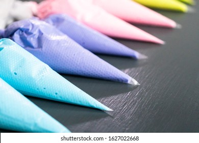 Variety of colors of royal icing in plastic piping bags.