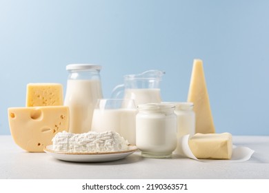 Variety of dairy products on blue background. Jug of milk, cheese, butter, yogurt or sour cream, cottage cheese. Farm dairy products concept