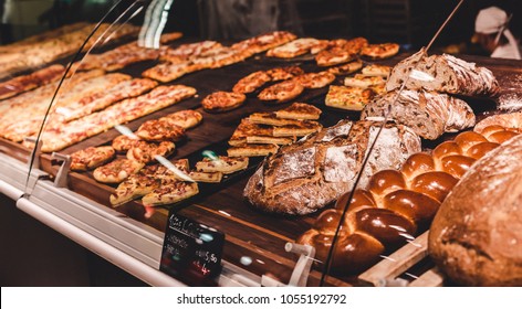 Variety of delicious breads, pizza, buns,pastry, displayed on shelves in Bakery shop